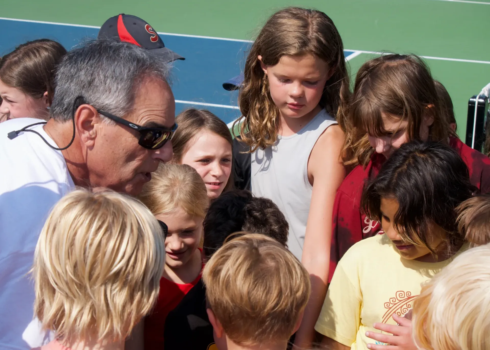 Mark Miller speaking with group of kids at pickleball lesson