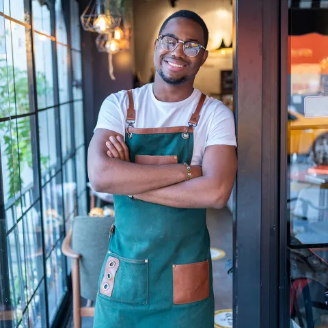 Small restaurant owner posing in restaurant